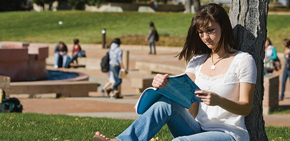 A student reading a book near University Plaza