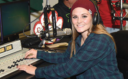 Student in broadcast room for Rev89 radio