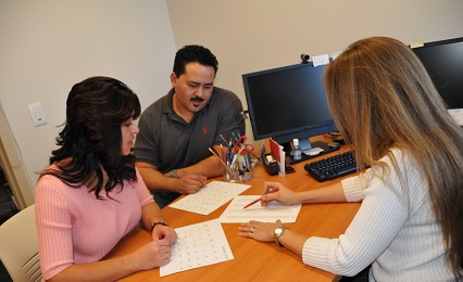 Advisor helping two adult learners with their application