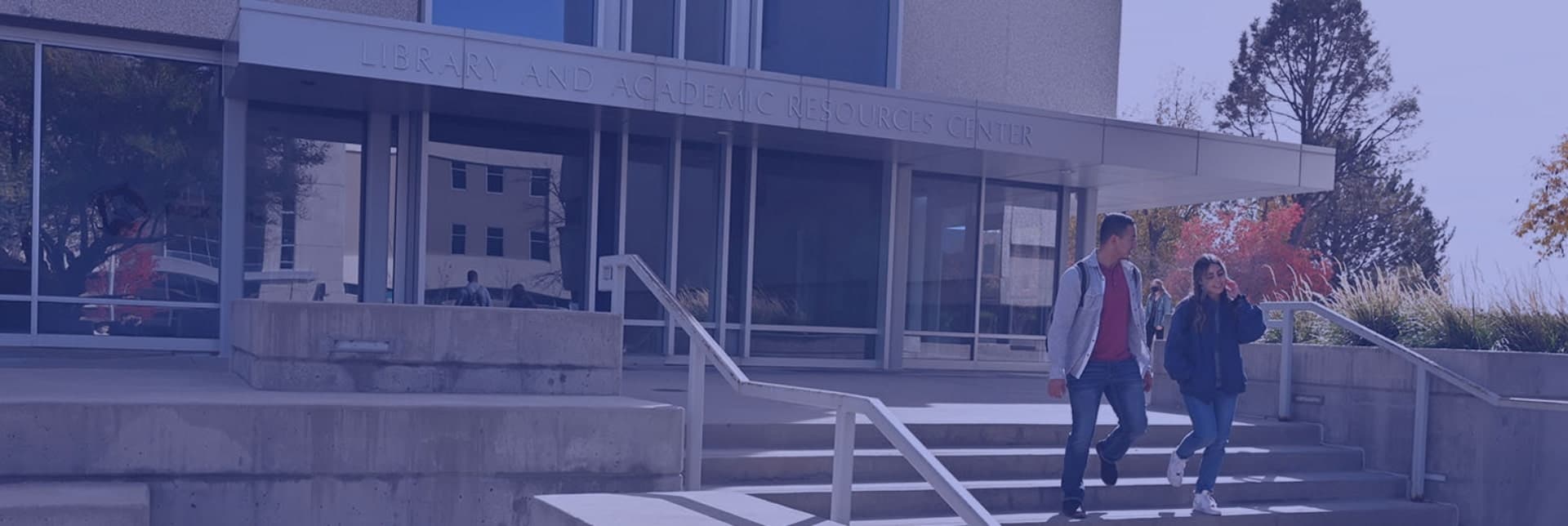 Students walking in front of the library on summer day