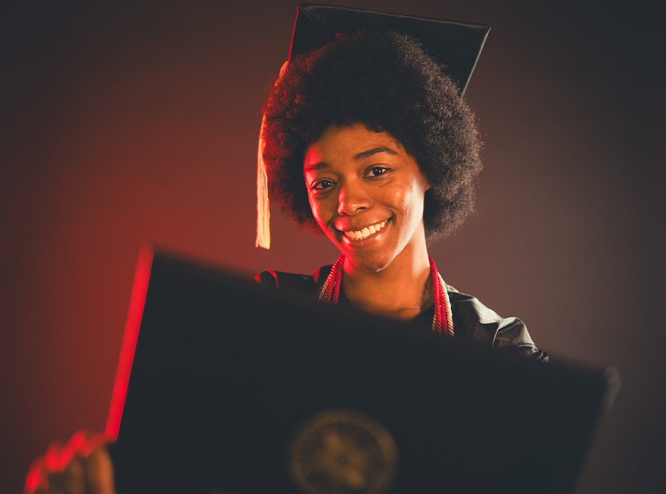 student holding dipolma cover