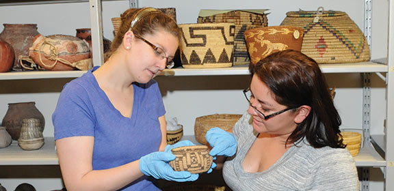 Individuals observing a piece of Southern Colorado artwork from CSU-Pueblo's University Archives and Special Collections