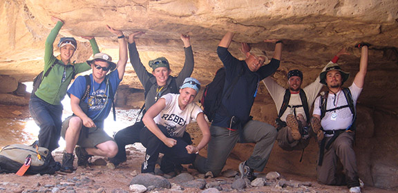Group of students pretending to hold up a giant boulder