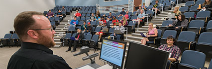 Education Technology Schedule Sign Up Banner. Diverse students look on toward a lecture in the room.