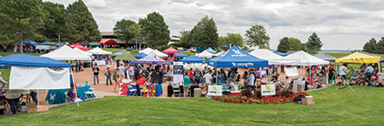 Students and vendors gather under pop tents near the fountain during the Student Employment and Involvement Fair.