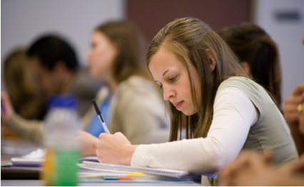 Student in classroom taking notes