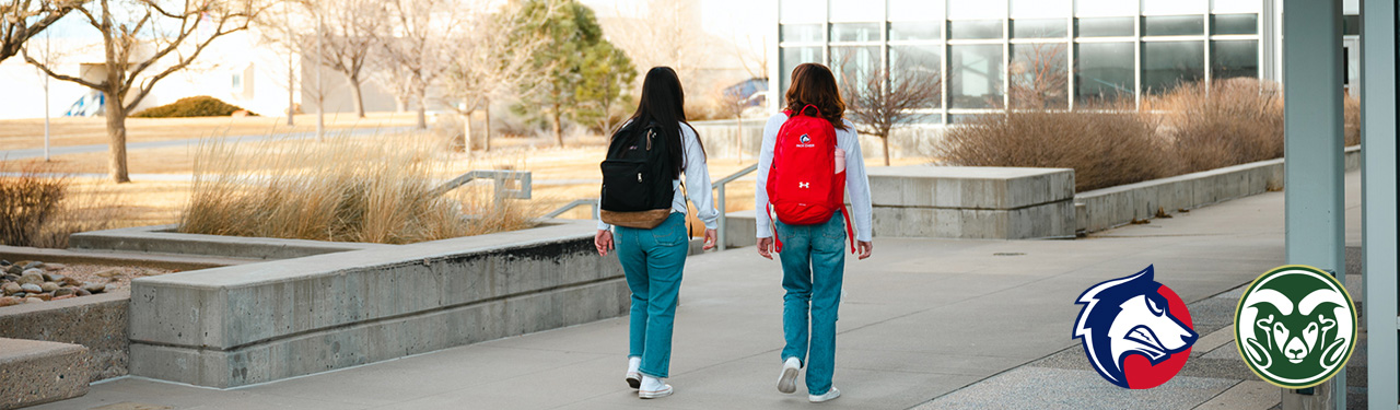 two students walking with csu fort collins and csu pueblo wolfie ram logos