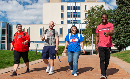 four students walking across campus