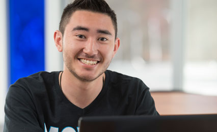 student sitting behind a laptop for a zoom meetings