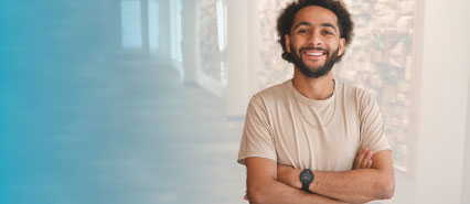 Student smiling at camera with arms crossed