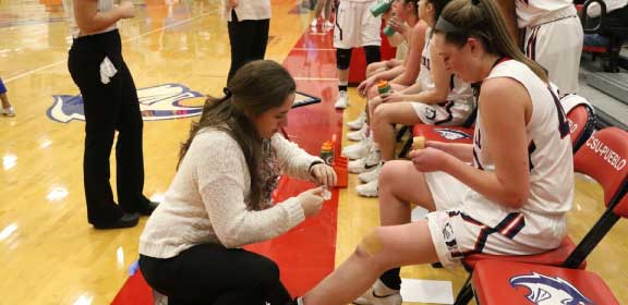 Trainer assisting basketball player