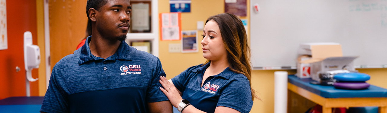 Athletic trainers assisting football players