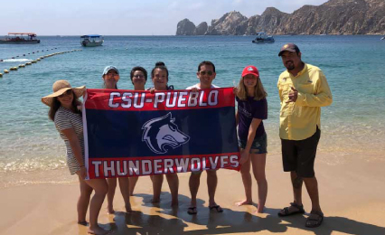 Students with professor in front of beach