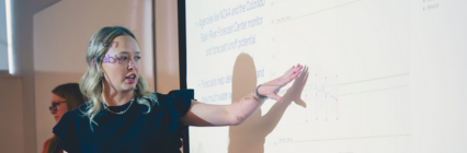 Girl pointing at whiteboard.