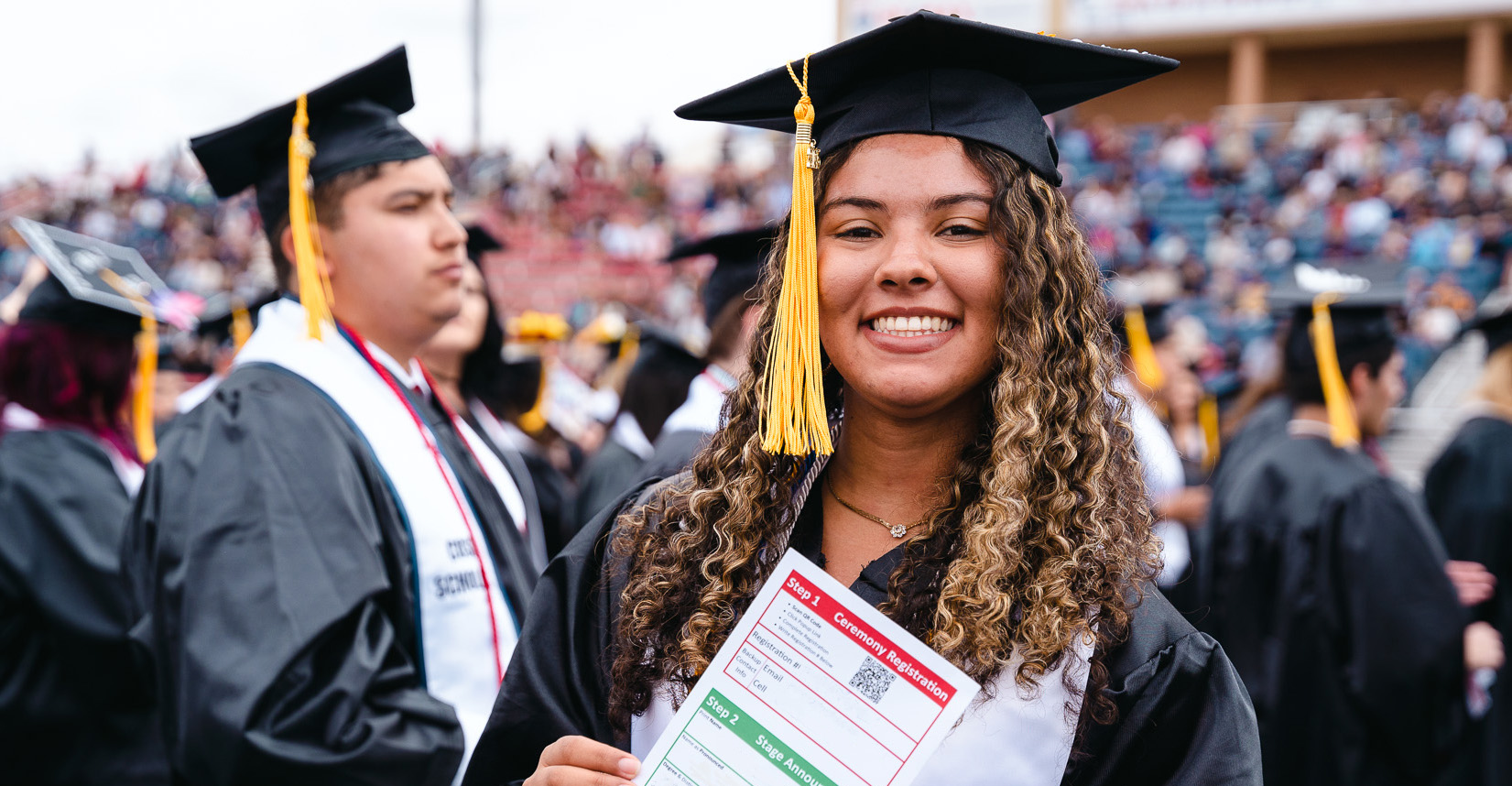 female graduate holding name card