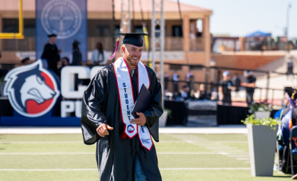 male graduate holding diploma cover