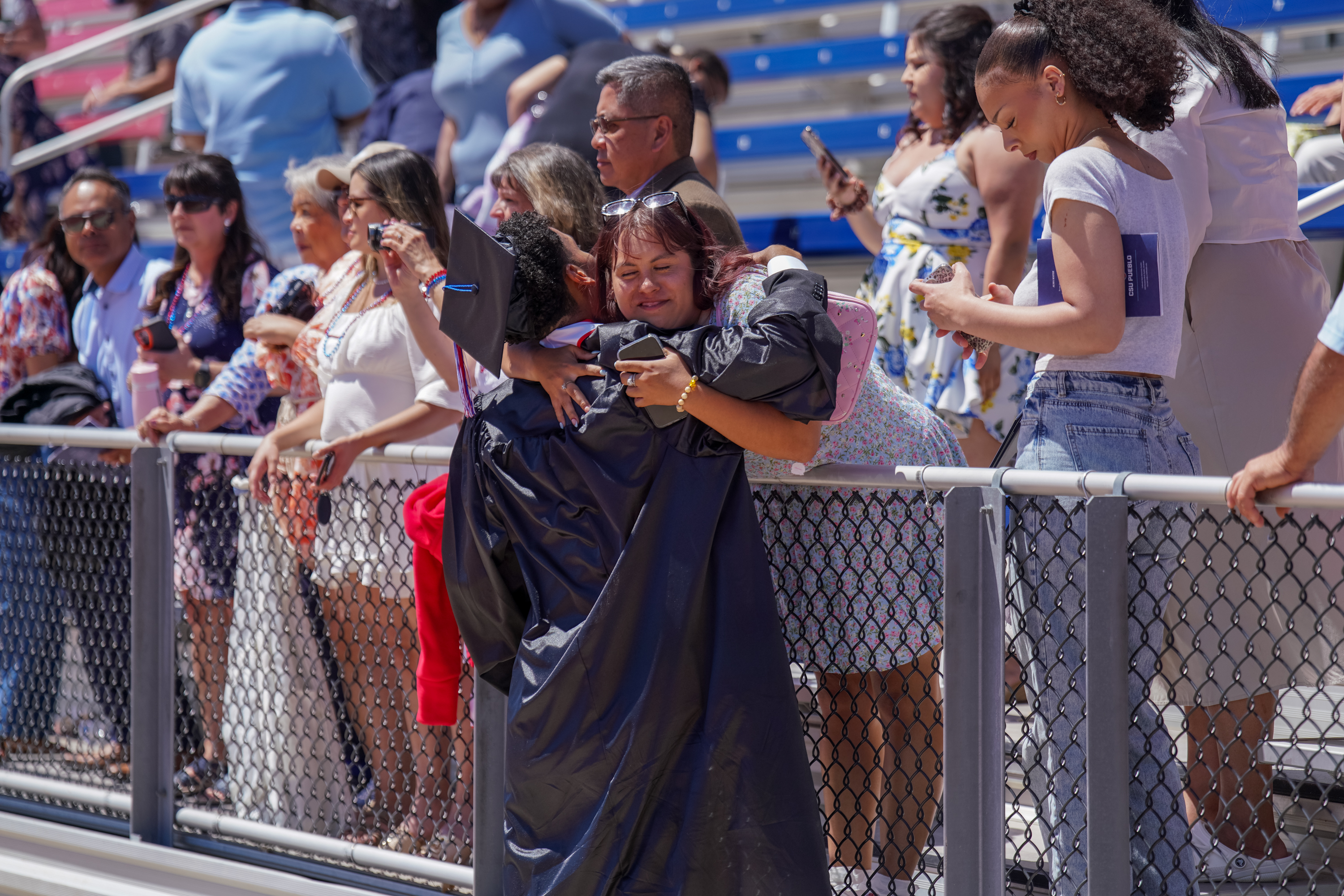 Guests hugging graduate at CSU Pueblo commencement
