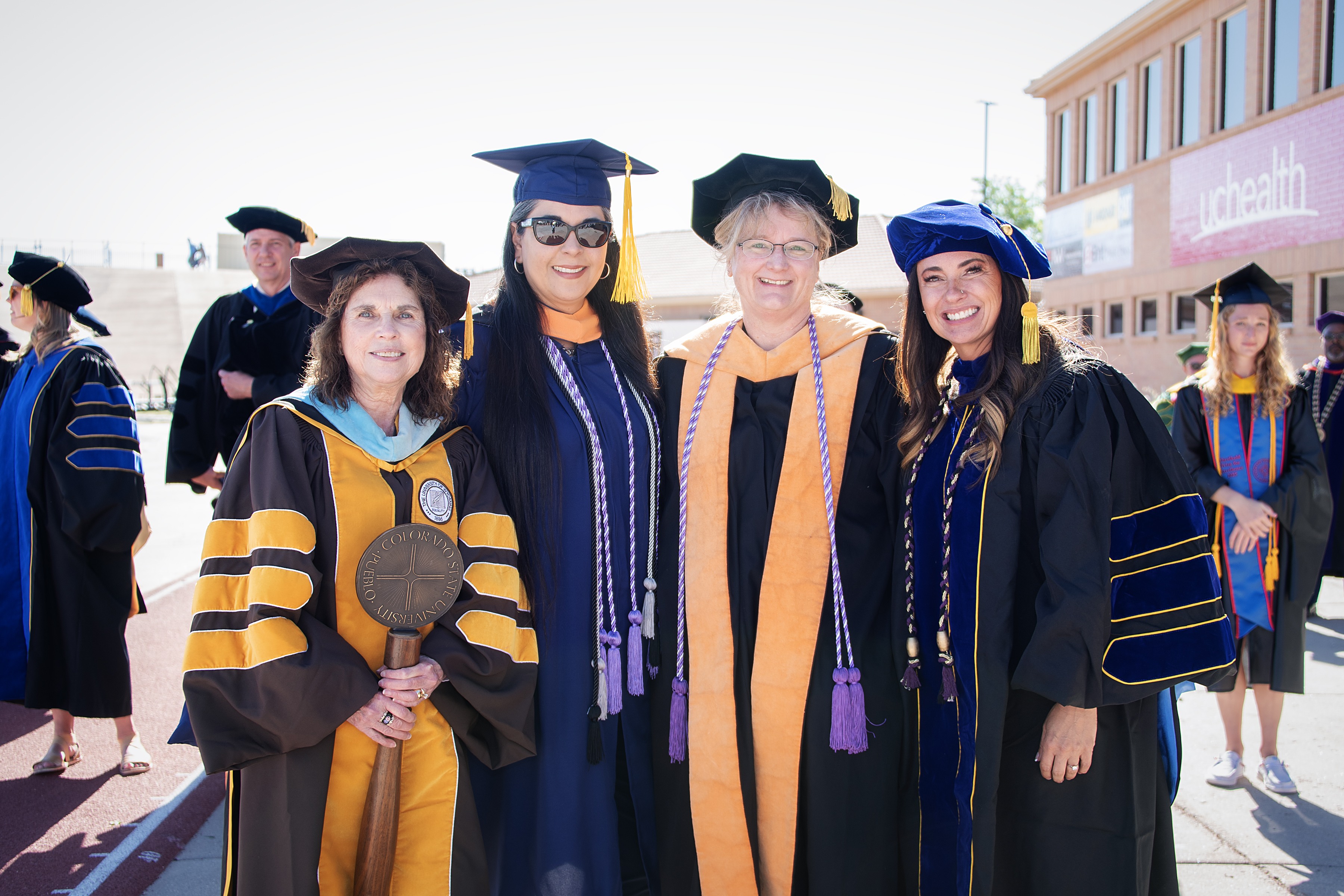 CSU Pueblo graduates smiling and celebrating after receiving their diplomas