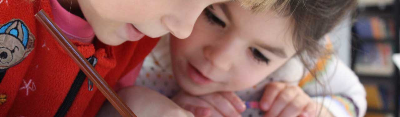 Two young kids looking at workbook