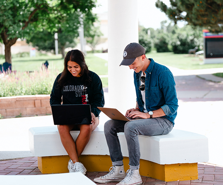 two students using laptop