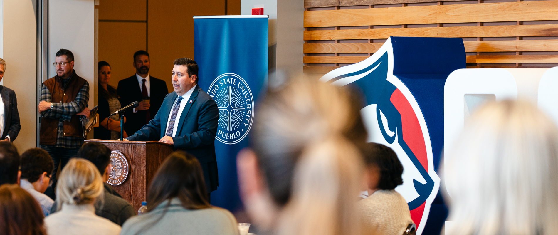 President Armando Valdez speaking to a crowded room after being named President of CSU Pueblo in December 2023.