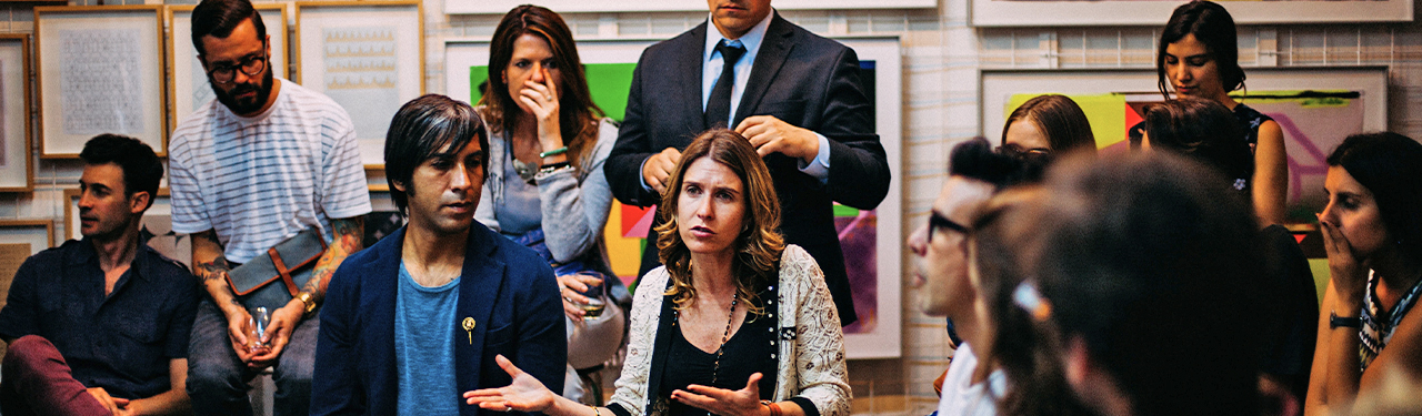Group of adults in a classroom having a discussion.