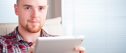 Adult learner with a tablet looking at camera