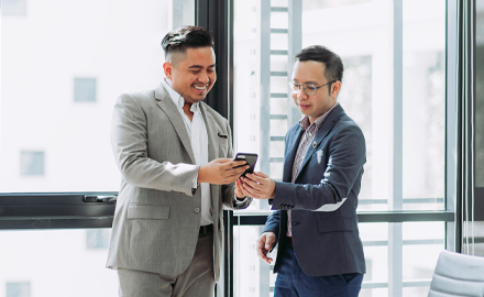 two business people looking at phone