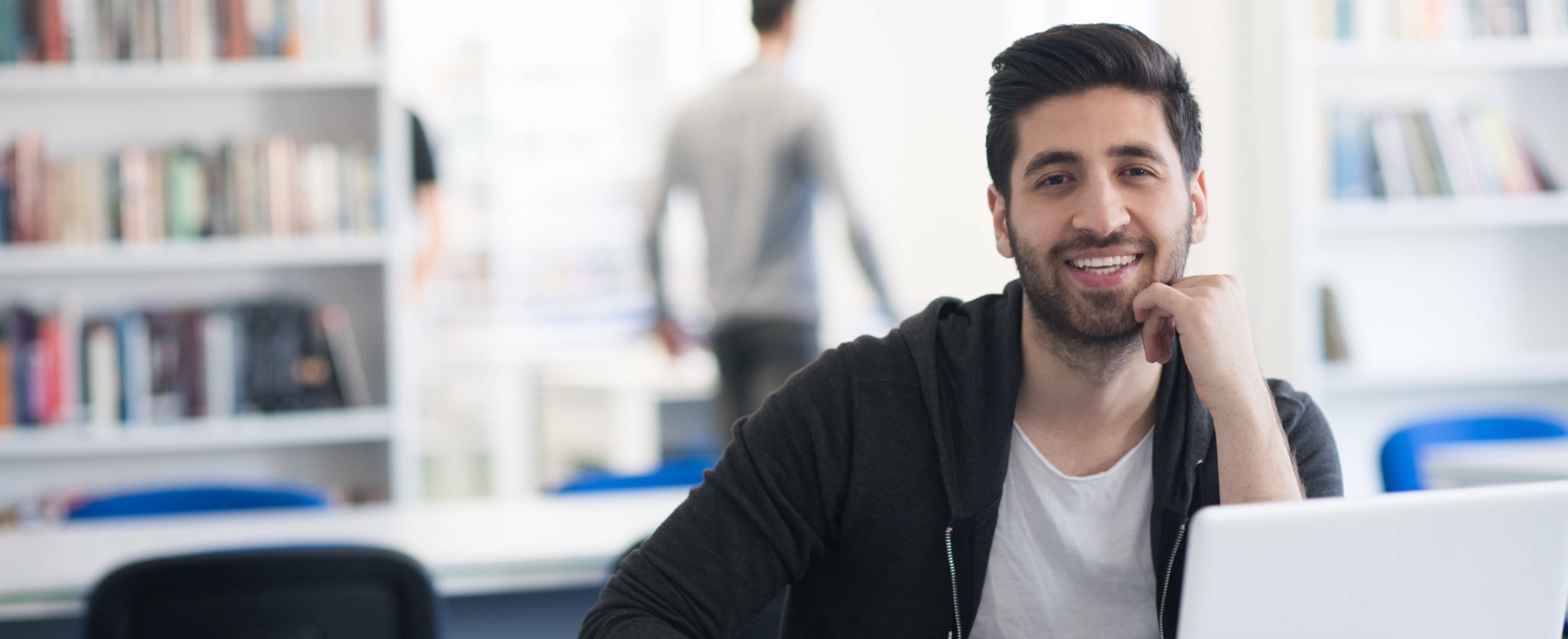 student smiling in front of computer