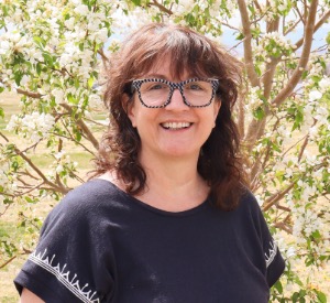 Jenny smiling in front of a tree