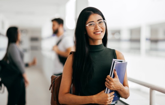 woman smiling with book outside