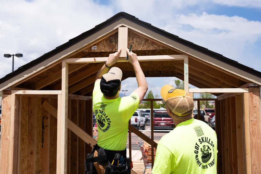 two people working on a small building