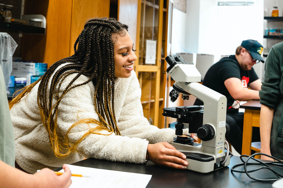 person using a microscope in class