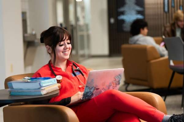 nurse smiling while on her laptop doing work