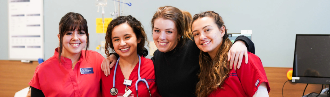 Nurses smiling at the camera in a hospital room