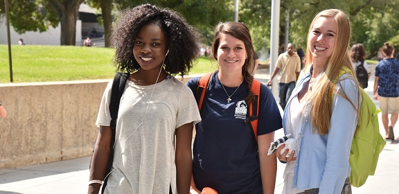 three students smiling at camera