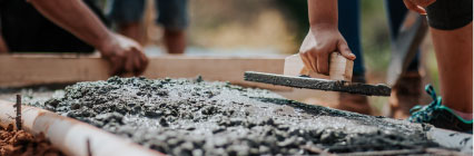 People putting cement on pavement