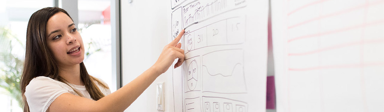 student pointing at white board