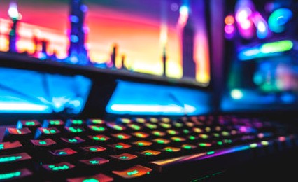 rainbow lit keyboard with monitors in background
